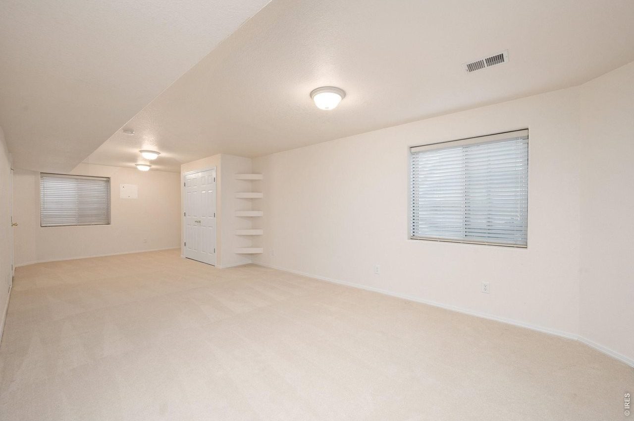 Finished lower-level family room with carpet and windows